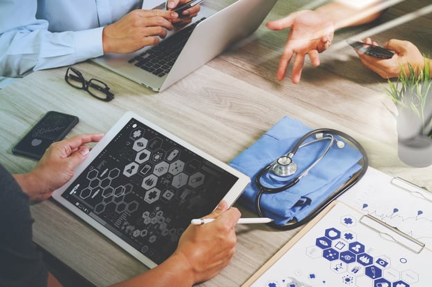 top view of Medicine doctor hand working with modern computer and digital pro tablet with his team with digital medical diagram on wooden desk as medical concept                               .jpeg